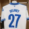 FC Copenhagen 2025-26 Kit Font White and blue FC Copenhagen 2025-26 jersey with the name "DELANEY" and number "27" printed on the back.