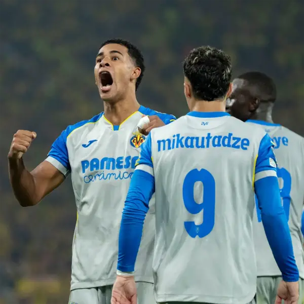 villarreal-cf-2026-2027 jersey Villarreal CF players celebrating on pitch wearing kit with cyan blue font nameplate mikautadze and number 9